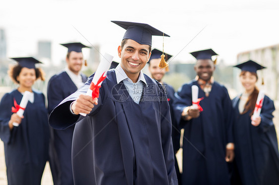 教育,毕业人的群快乐的国际学生迫击炮板学士学位礼服与文凭文凭的迫击炮板上快乐的学生图片