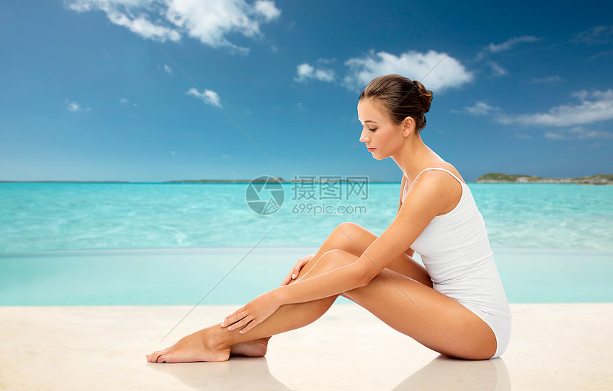 美丽 脱毛 人身体护理的美丽的女人触摸她光滑的光腿异国情调的热带海滩背景美丽的女人海滩上抚摸她光滑的腿高清图片下载 正版图片 摄图网