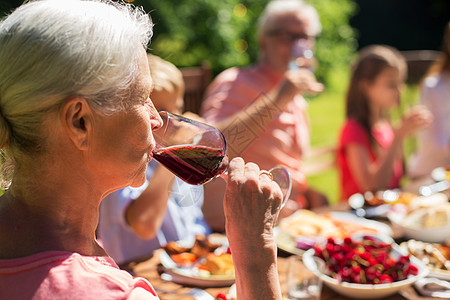 节日,酒精人的老年女子家庭节日晚餐夏季花园聚会上喝红酒高级女人家庭晚餐上喝酒图片