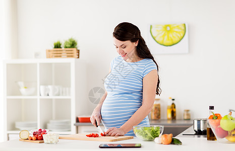健康饮食,怀孕人的孕妇烹饪蔬菜沙拉切樱桃西红柿家里厨房孕妇家煮蔬菜图片