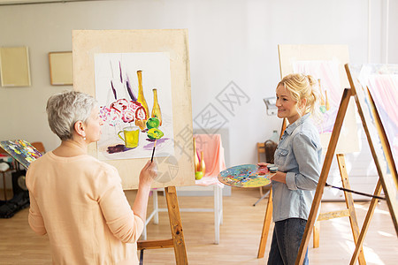 创造力教育人的女艺术家艺术学校工作室的画架上画静物画谈话艺术家妇女与画架绘画艺术学校图片