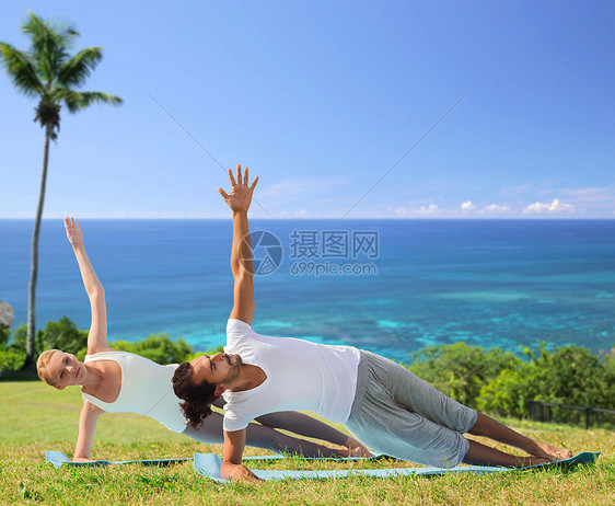 健身,运动人的快乐的夫妇瑜伽冥想异国情调的自然背景与棕榈树海洋快乐的夫妇海滩上瑜伽练图片