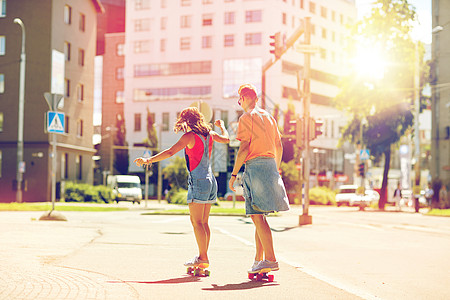 夏天,极限运动人的十几岁的夫妇骑着短的现代巡洋舰滑板城市街道轻夫妇城市街道上骑滑板图片