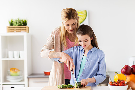 烹饪食物,健康饮食,家庭人的快乐的母亲女儿家里厨房切菜快乐的家庭烹饪晚餐家厨房图片