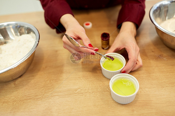 烹饪,烘焙人的厨师的手添加食物颜色与鸡蛋清碗厨师用蛋清把食物颜色加碗里图片