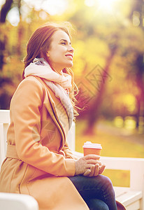 季节,热饮人们的美丽的快乐轻女人喝咖啡茶次纸杯坐长凳上的秋天公园快乐的轻女人秋天的公园喝咖啡图片