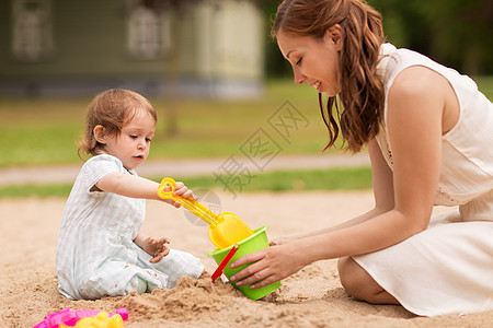 母亲在沙滩上陪孩子玩耍背景图片