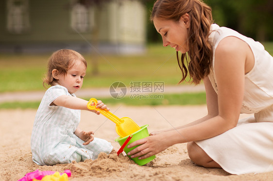 母亲在沙滩上陪孩子玩耍图片