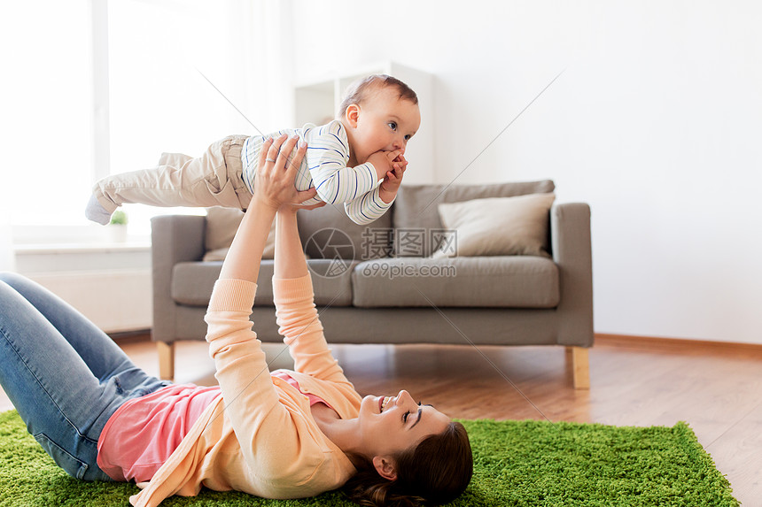 微笑的年轻母亲和小婴儿快乐的玩耍图片