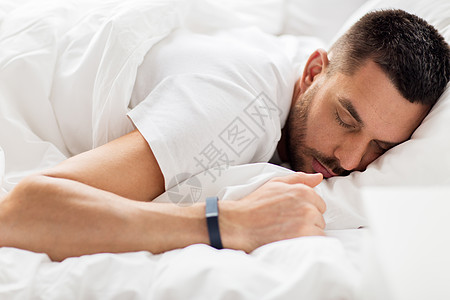 人,睡觉时间休息智能手表的人睡床上智能手表的男人睡床上图片