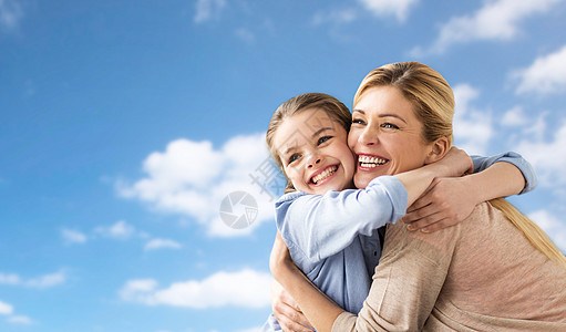 人们家庭的快乐的微笑女孩与母亲拥抱蓝天云彩的背景幸福的家庭女孩母亲拥抱天空图片