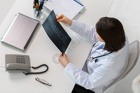 医学,医疗外科医生外科医生与脊柱X光坐桌子上医生脊柱X光坐桌子上背景图片