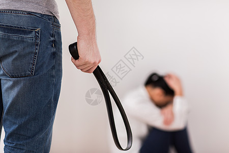 虐待人的男人用皮带殴打无助的害怕女人遭受的幸妇女图片