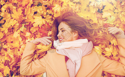 季节人的美丽的轻女人躺地上秋天的叶子上美丽快乐的女人躺秋叶上图片