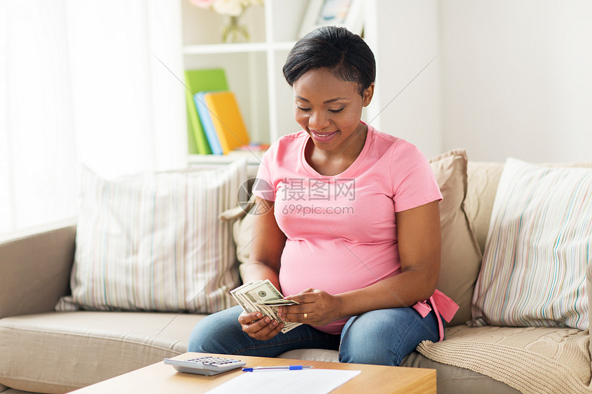 ‘~储蓄,财政人的快乐的怀孕非裔美国妇女与文件计算器计数家里的钱快乐的孕妇家数钱  ~’ 的图片