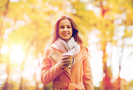 季节,热饮人们的美丽的快乐轻女人喝咖啡茶次纸杯秋季公园快乐的轻女人秋天的公园喝咖啡图片