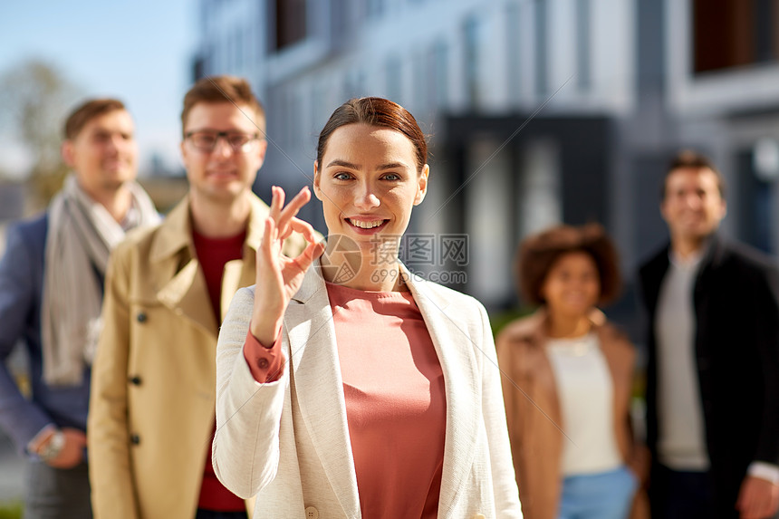 商业,手势公司快乐的微笑的女人与国际人群良好的手势户外快乐的微笑的女人户外展示OK手势图片