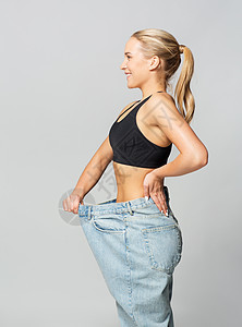 健身,饮食,减肥人的轻的苗条运动妇女穿着超大的裤子穿着超大裤子的轻苗条运动女人图片