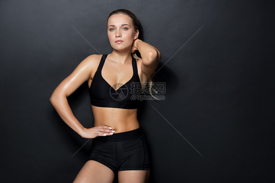 运动,健身人的轻的女人穿着黑色运动服健身房摆姿势穿着黑色运动服的轻女人健身房里摆姿势图片