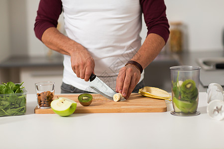健康饮食,素食,饮食人的男人与搅拌机水果烹饪家里厨房家里厨房里搅拌机水果烹饪的男人图片