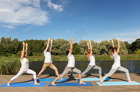 健身,运动健康的生活方式群人河边湖边的战士姿势瑜伽群人户外瑜伽练图片