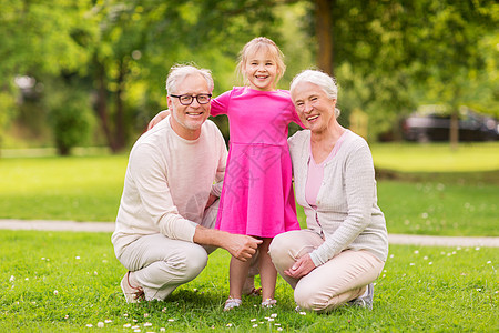 家庭,世代人的快乐的微笑祖母,祖父小孙女公园公园的祖父母孙女图片