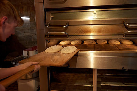 食物,烹饪烘焙包师与果皮,将酵母放入包烤箱包店厨房包师把放进包店的包烤箱里图片