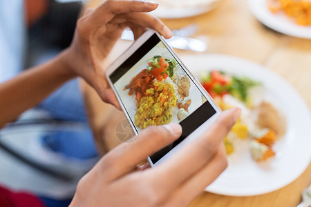 技术,饮食人的手与智能手机拍照食物餐厅手智能手机想象餐厅的食物图片