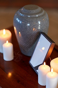 葬礼哀悼相框与黑色丝带,火化瓮燃烧蜡烛桌子上的教堂相框,火化瓮桌子上的蜡烛图片