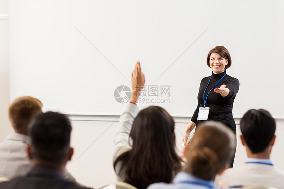 商业,教育人的微笑的女商人教师,会议演讲讲座上远程回答问题出席商务会议讲座的群人图片