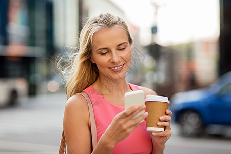 沟通,技术人的快乐的微笑轻妇女与咖啡智能手机城市街道城市里咖啡智能手机的女人图片