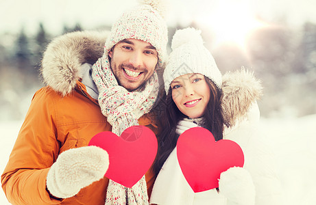 人,季节,爱情人节的幸福的夫妇抱着空白的红心冬天的风景幸福的夫妇与红心冬天的风景图片