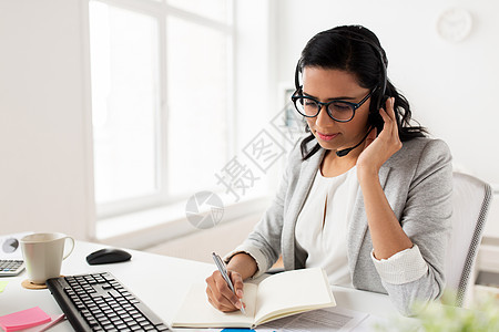 沟通,商业,人技术微笑的女商人帮助热线接线员与耳机交谈办公室带耳机的女商人办公室说话图片
