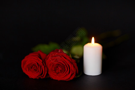 红色小图标葬礼哀悼的红色玫瑰燃烧的蜡烛黑色的背景红色玫瑰燃烧的蜡烛黑色的背景上背景