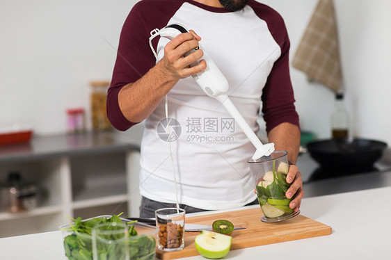 健康饮食,素食,饮食人的男人与搅拌机水果烹饪家里厨房家里厨房里搅拌机水果烹饪的男人图片