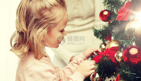 家庭,诞节,寒假人们的快乐的小女孩家里妈妈装饰诞树小女孩家装饰诞树图片