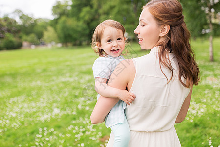 家庭,童父母的快乐的母亲抱着小女婴夏季公园快乐的母亲夏天的公园抱着女婴图片