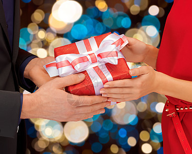 假日人们的亲密的情侣手着礼品盒灯光背景紧紧地握住礼品盒的双手图片