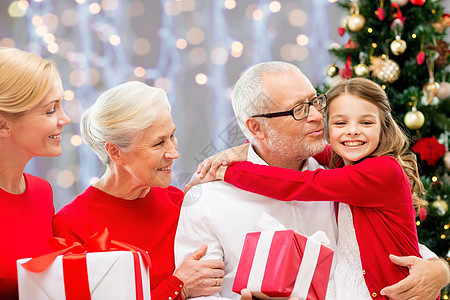 寒假,家庭人的快乐的祖父母孙女与诞礼物灯光背景幸福的家庭带着诞礼物灯光下图片