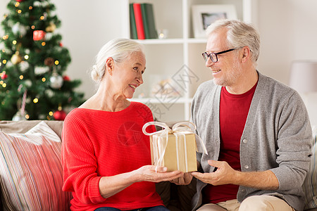 诞节,假日人的快乐的微笑老夫妇与礼品盒家里幸福微笑的老夫妇带着诞礼物图片
