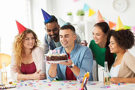 公司聚会人的快乐队与蛋糕非酒精饮料庆祝同事21岁生日办公室聚会生日蛋糕队的男人办公室聚会上图片