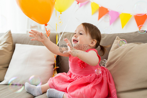 童,人庆祝快乐的女婴家里的生日聚会快乐的女婴家里的生日聚会上图片