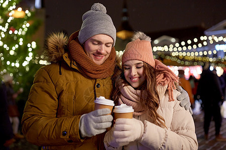 寒假,热饮人们的快乐的轻夫妇诞节市场晚上喝咖啡快乐的轻夫妇诞市场喝咖啡图片