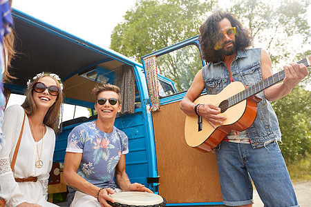 暑假,公路旅行,旅行人们的快乐的轻嬉皮朋友与吉他汤姆鼓小货车车里玩得开心演奏音乐快乐的嬉皮士朋友小货车里演图片