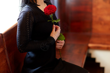 人们,悲伤哀悼的亲密的女人与红玫瑰坐长凳上的葬礼教堂教堂的葬礼上用玫瑰紧紧地拥抱女人图片