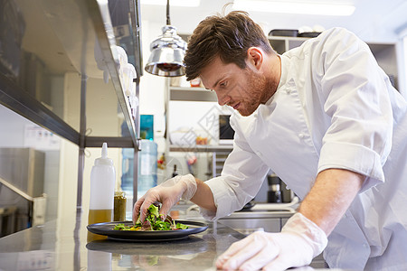 食物烹饪,职业人的快乐的男厨师餐厅厨房蔬菜沙拉快乐的男厨师餐厅厨房烹饪食物图片