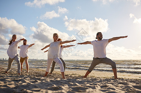 健身,运动,瑜伽健康的生活方式群人海滩上战士的姿势群人海滩上瑜伽练图片