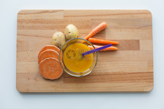 婴儿食品,健康饮食营养蔬菜泥婴儿食品碗与喂养勺子木板上蔬菜泥婴儿食品用勺子放碗里图片