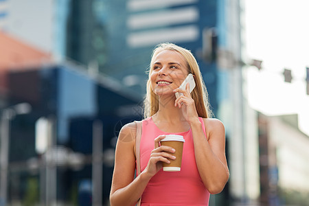 沟通,技术人的快乐的微笑的轻与咖啡呼叫智能手机城市街道城市里咖啡的女人打电话给智能手机图片