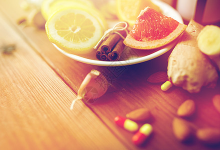 医疗保健,传统医学民族科学肉桂,柠檬柚子与药物药丸木桌上传统医学药物图片